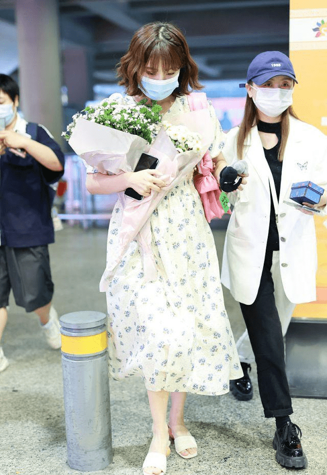 李艺彤穿白色碎花裙背粉色包包手捧鲜花太迷人像个小公主
