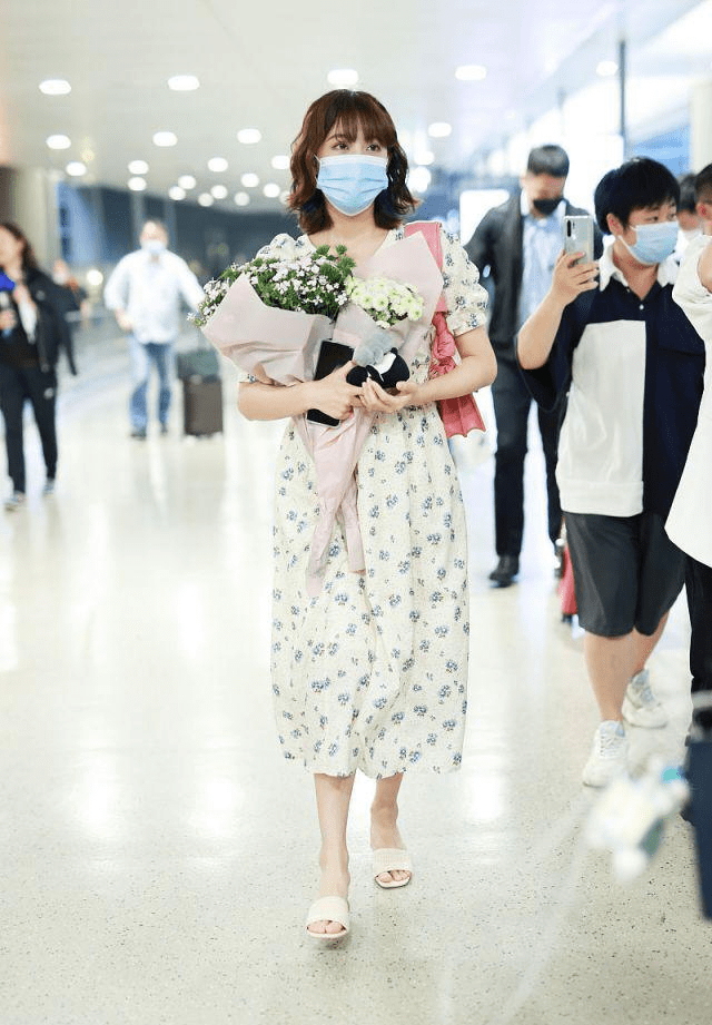 李艺彤穿白色碎花裙背粉色包包手捧鲜花太迷人像个小公主