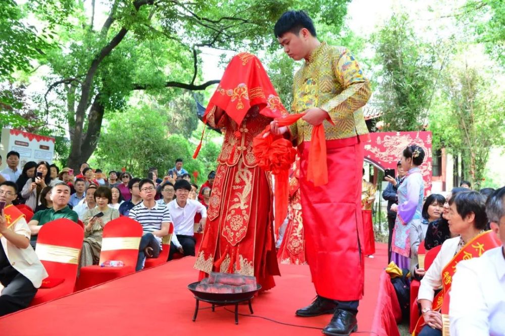 迈火盆,跨马鞍,掀盖头,授秤杆等传统习俗依次完成了10对牵着红绸的