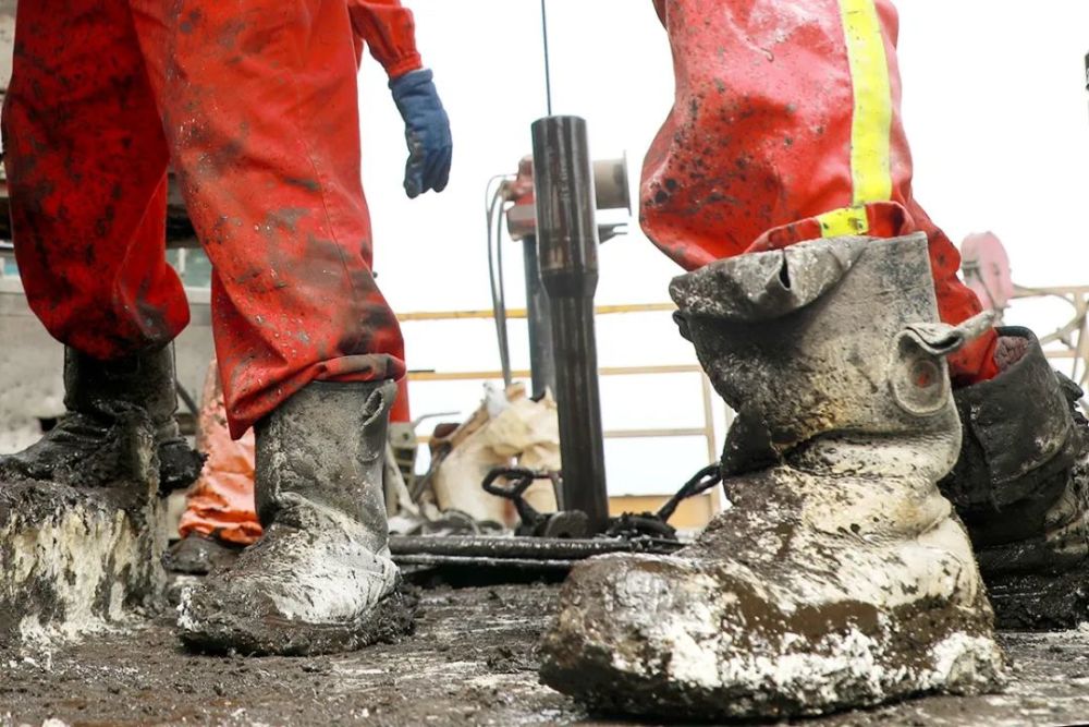 4月28日,西部钻探克拉玛依钻井公司员工穿着沾满了泥浆的工鞋在钻台上