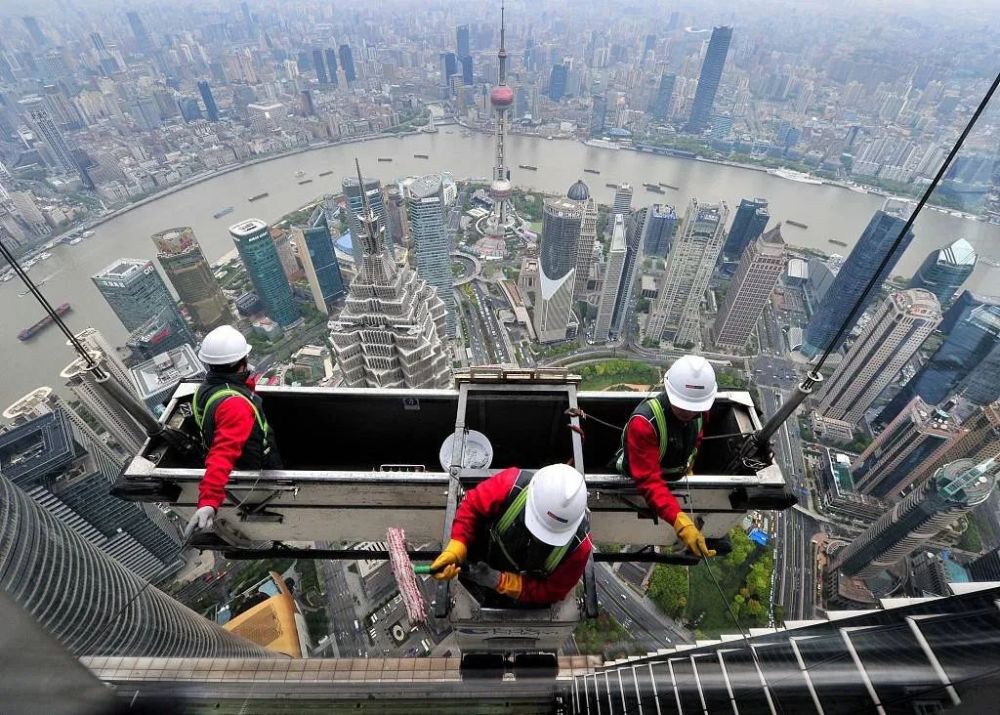 中心的户外幕墙清洗人员乘坐吊篮在500米高空的观光厅外墙进行作业