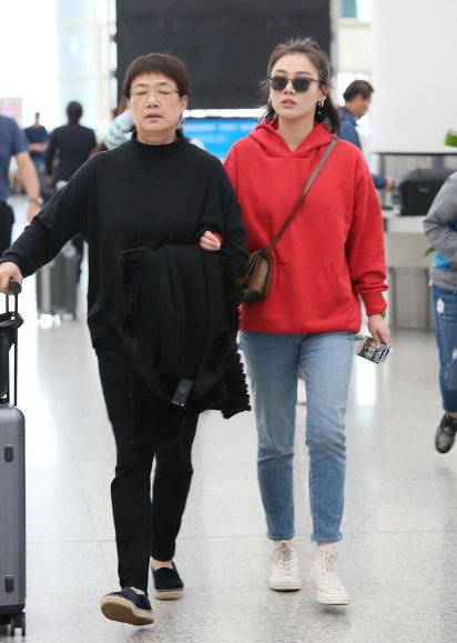 马思纯携妈妈走机场,身穿红色卫衣显圆润,体型一看就是母女俩