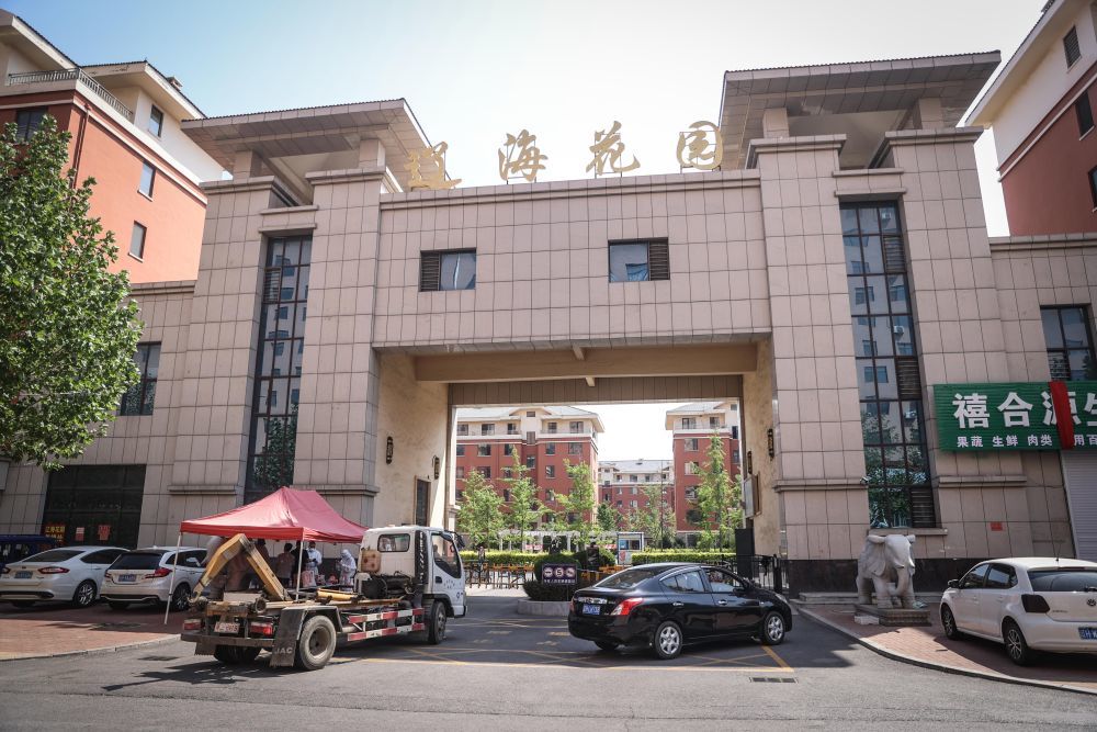 工作人员在鲅鱼圈区熊岳镇辽海花园小区入口值守.