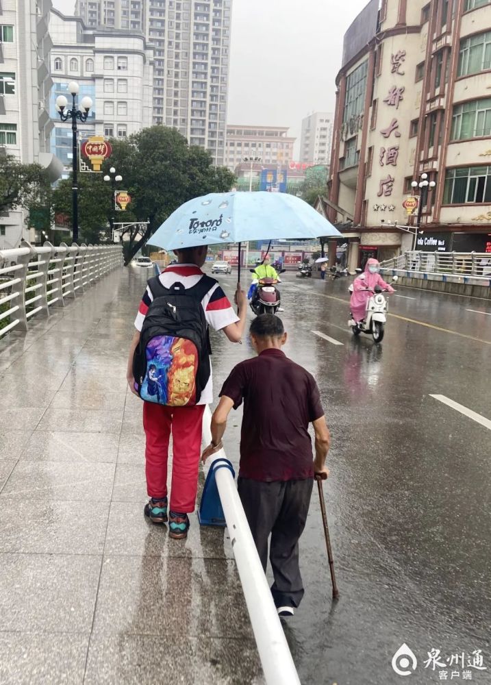 这两天,一张德化县第二实验小学学生在暴雨中为一名行动不便的老人