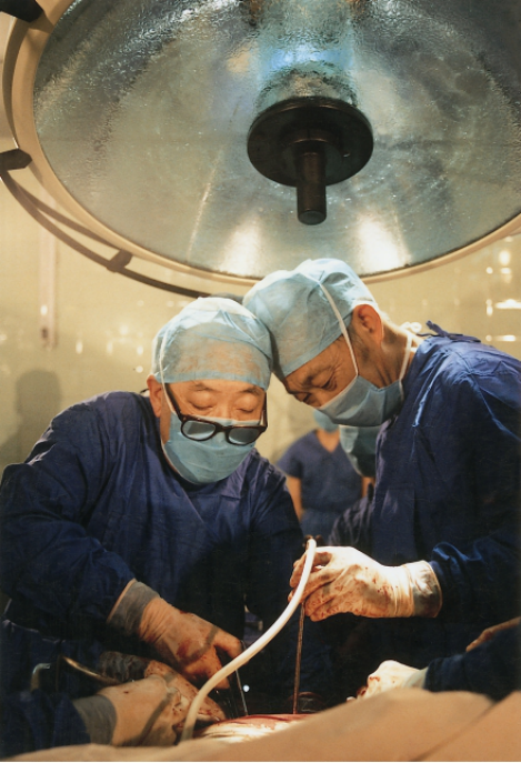 吴孟超与手术助手陈汉医生合作做手术(吴孟超办公室提供)