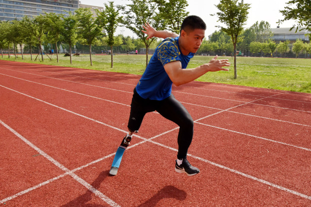 新华社记者 李紫恒 摄5月24日,李茂大换上跑步专用假肢开始训练.