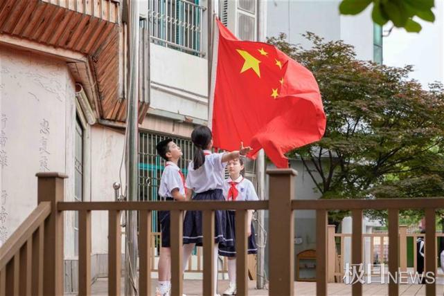 大手牽小手大學生和小學生一起升國旗