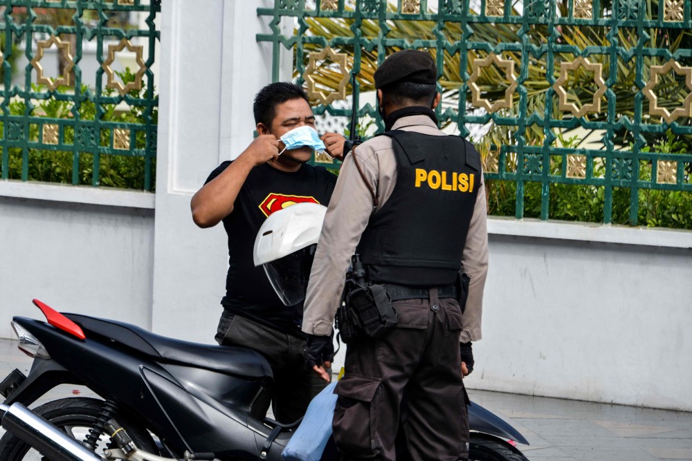 新华社/法新5月28日,印尼警察在班达亚齐街头喷洒消毒剂.新华社/法新