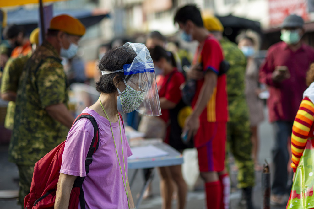 5月29日,戴着口罩的市民在马来西亚吉隆坡一处市场内购物.