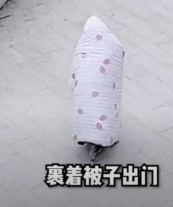 只见她裹着被子全副武装骑着自行车出门,这种哗众取宠的行为引来了