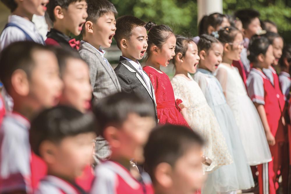 操场上,一年级小学生用稚嫩的童音演唱《党是太阳我是花》.