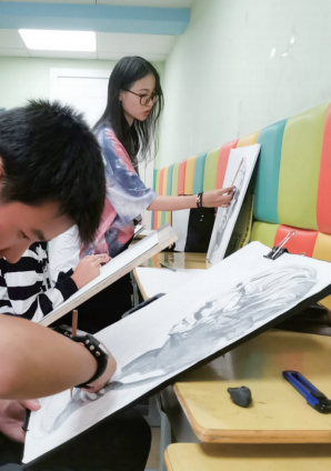 正在教小朋友画画的小杨老师