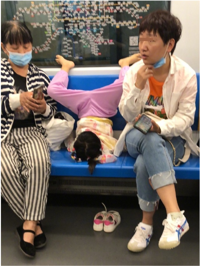 北京地铁小女孩"倒挂金钟" 脚趾夹棒棒糖吃 家长拒管教