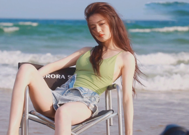 徐璐在沙滩上拍大片穿吊带装身形饱满坐姿狂野英气逼人