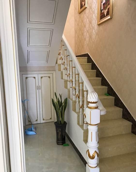 这是通往房间的过道和通往楼上的楼梯,过道的今天摆了一张条案和一幅