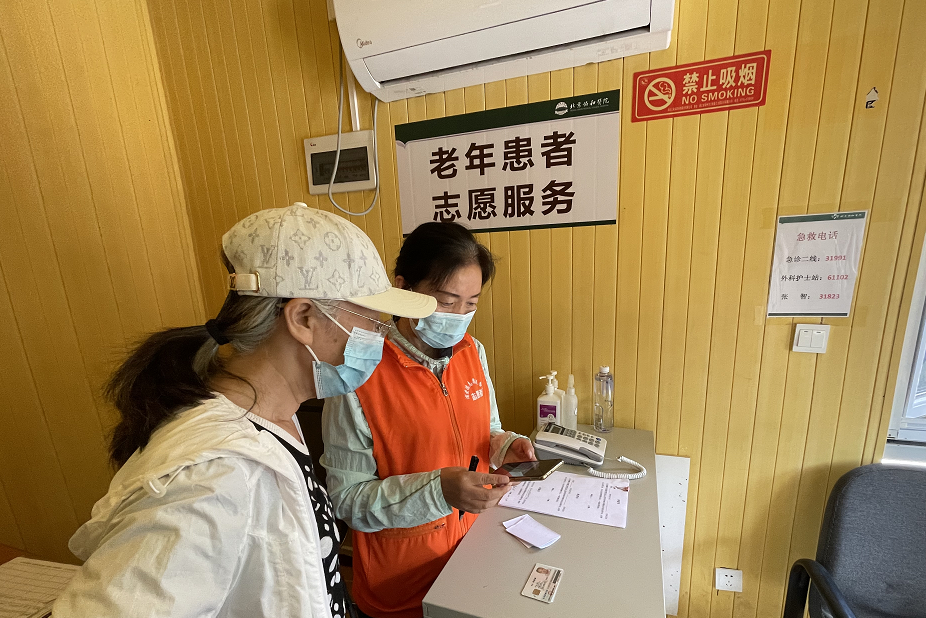 协和医院门口有一间不起眼的小屋,是专门为老年患者准备的助医服务站