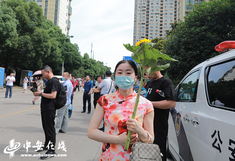 一位考生媽媽穿著旗袍,舉著葵花祝願兒子