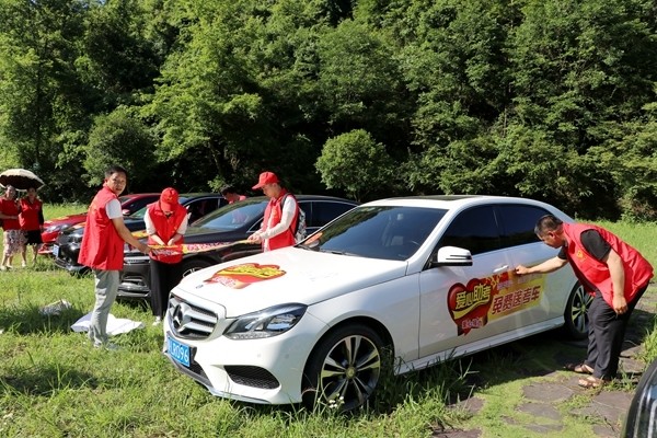 通道县义工志愿者在独岩风景区内,给免费送考车辆张贴"爱心助考直通车