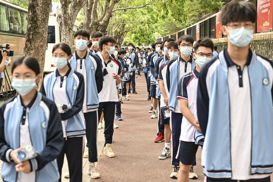 2021年6月7日,广州市育才中学考点,老师将红绳系在考生的手腕上.