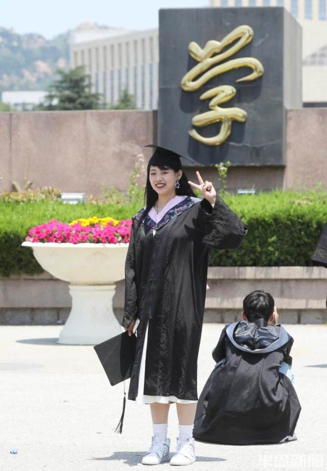 校园门口留念6月3日,青岛大学操场上,几名毕业生在这里拍照留念.
