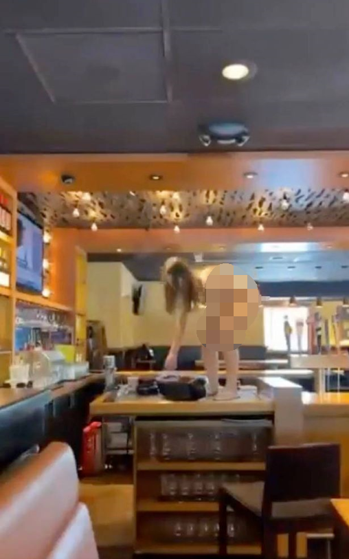 美国女子光着全身闯进餐厅到处撒野乱扔酒瓶被警方击中胸部倒地