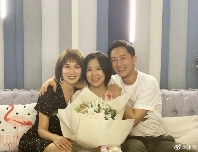 照片中,韩庚的妈妈赵继芳女士坐在最中间,手上拿着一大束花,韩庚和