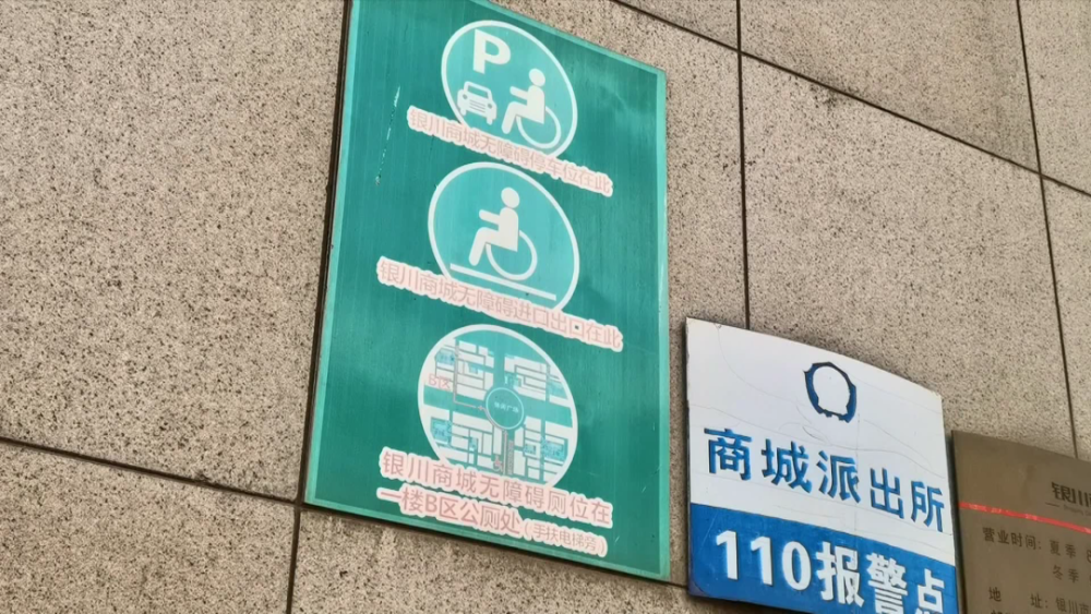 的银川商城西门口一处地面停车场上,虽然设置有无障碍停车位的标识牌