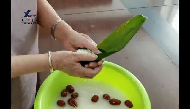 5,用马莲围着粽子形状系紧实,最后打一个十字扣,粽子就包好啦.