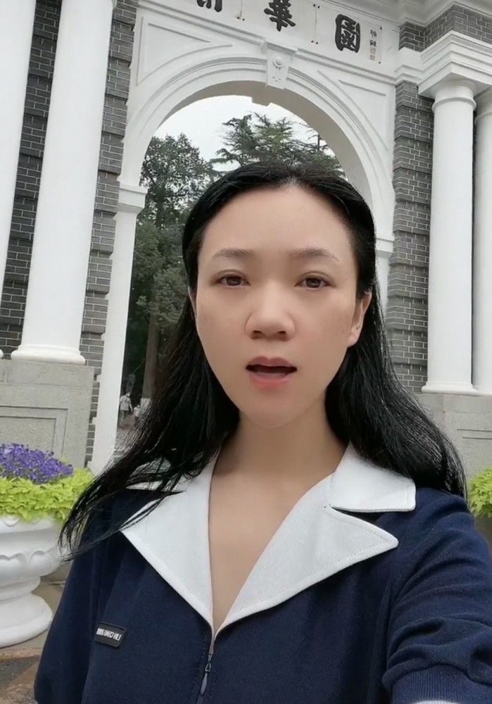 从视频中可以看出周群身穿深蓝色上衣,白色的领子显得整个人很有气质