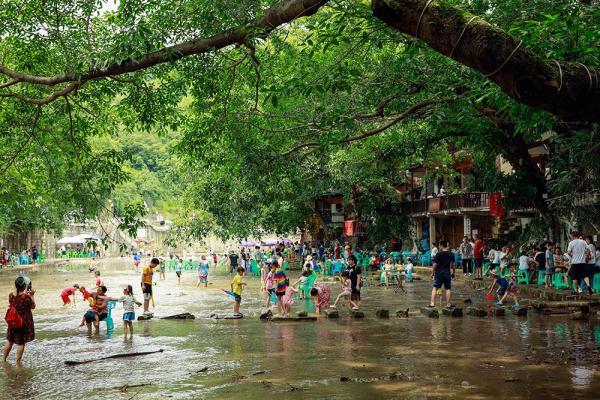 6月14日,遊客在重慶市北碚區偏巖古鎮納涼戲水.