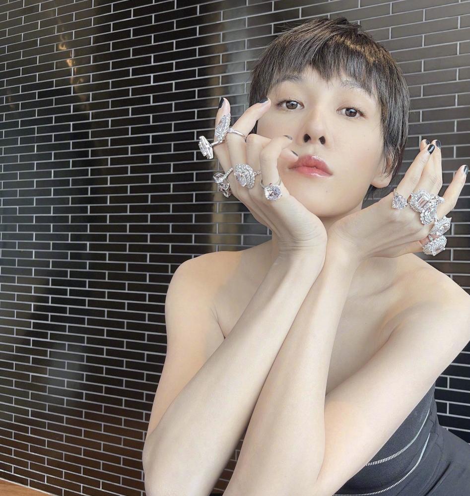 张蓝心十个手指戴满"鸽子蛋",一袭黑色修身抹胸裙,贵气奢华