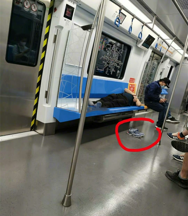 北京一男子地铁脱鞋霸座睡觉有人趁他睡着将他一只鞋踢出车外