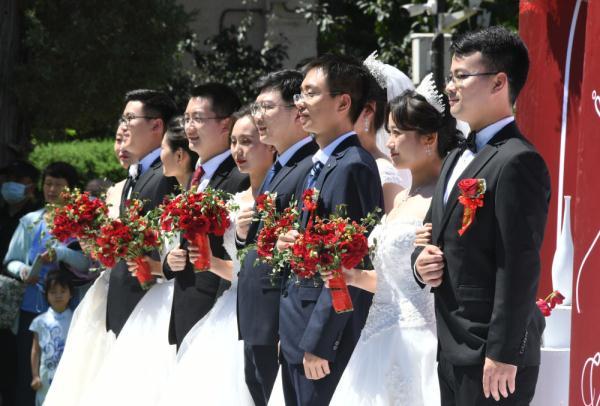 6月19日,在北京理工大學中關村校區中心花園,新人參加集體婚禮.