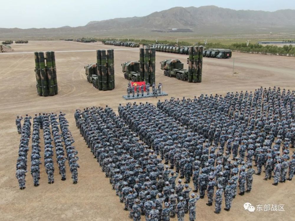 任务间隙,在功勋发射车前党员干部为大家讲述部队砺剑戈壁的故事