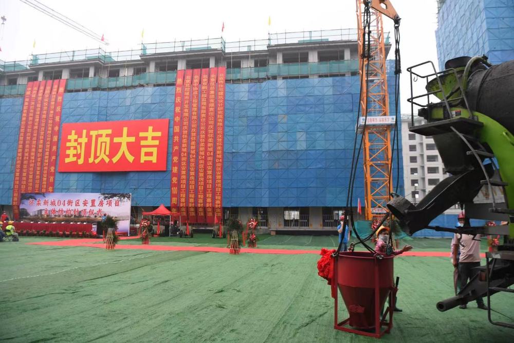 数十栋簇新的楼房已经拔地而起,非常壮观,楼上"封顶大吉"的红条幅更是