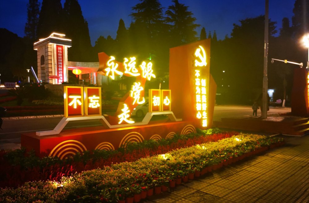 广场等重要节点布置了花卉,安装了宣传标识牌,党徽雕塑,灯箱等,营造