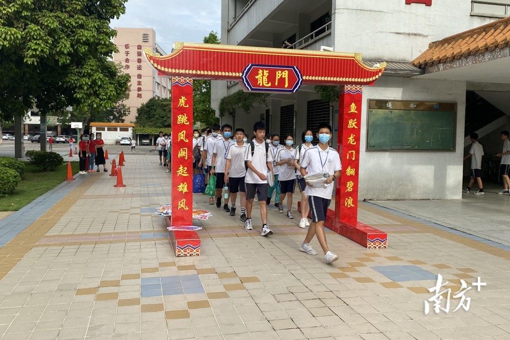 老师和考生击掌鼓劲6月26日早上7时许,记者在望牛墩中学考点看到,在