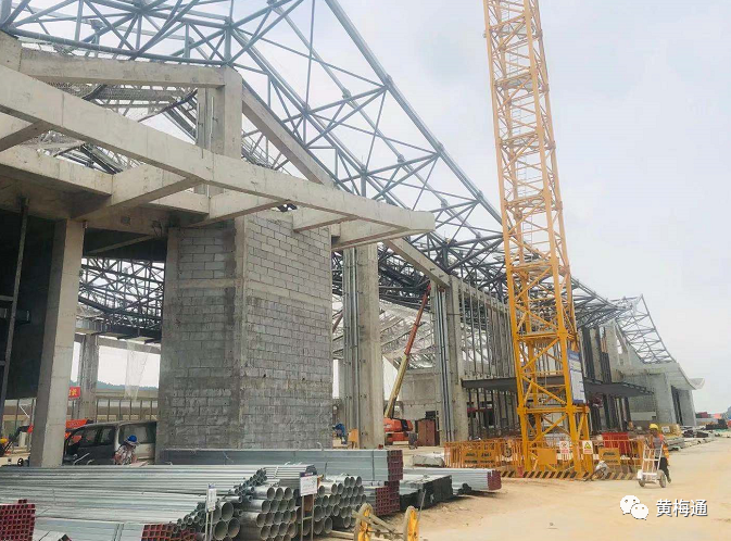 在黄梅东站项目施工现场,施工人员正在进行内墙装饰,雨棚安装及试装