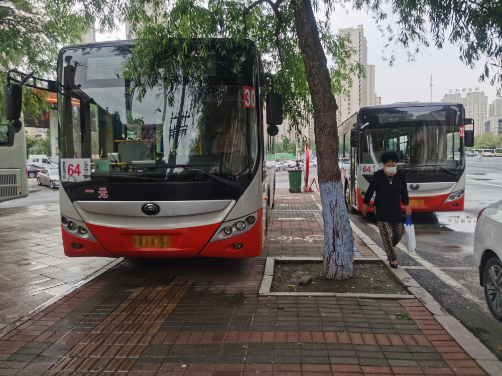 哈尔滨64路公交车停在人行道上行人无路可走