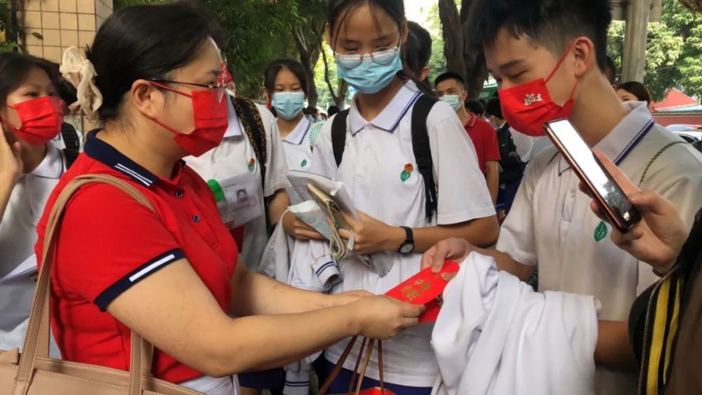 荔湾区真光中学考点,同学们陆续到达准备入场家长们大多穿上红色衣服