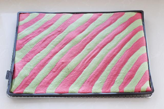 在表面覆盖一张油纸,放上烤网翻到另外一面,慢慢揭掉表面蛋糕卷模具晾