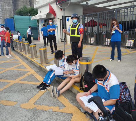 毓贤学校领导和九年级全体教师穿上蓝色的"冠军"送考服站在学校百步梯