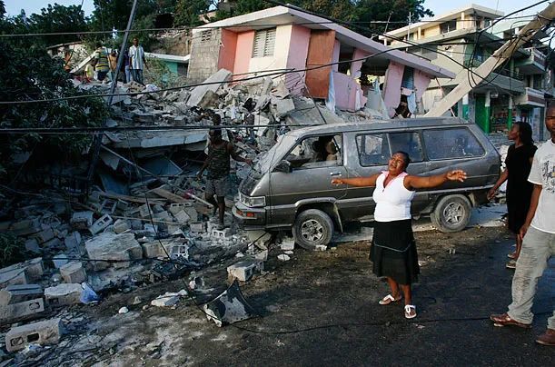 2010年,在发生地震的海地首都太子港,一名女子在被震毁的房屋旁哭泣