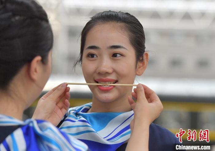 在长春站,长春客运段的动姐咬筷子练习微笑 张瑶 摄