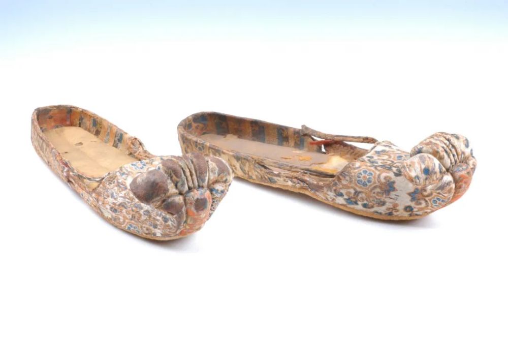 履出土,如1969年阿斯塔那381号墓出土的一双唐代变体宝相花纹云头锦鞋