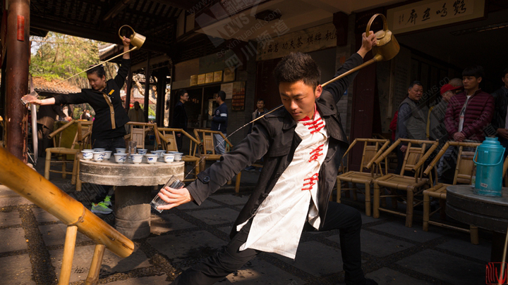 堂倌边唱喏边流星般转走,右手握长嘴铜茶壶,左手卡住锡托垫和白瓷碗