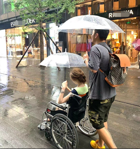 网红覃美莹作秀!雨天坐轮椅出行称脚有洁癖,晒美照却光脚踩马路