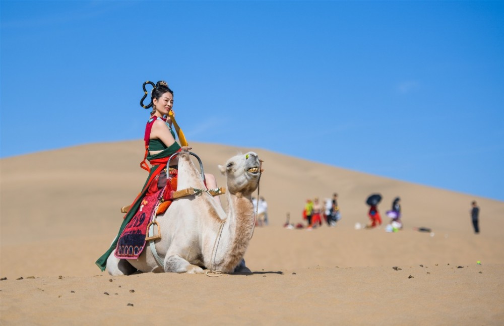 在敦煌,游客可化身"飞天",在鸣沙山拍摄"大漠飞天"旅拍片.