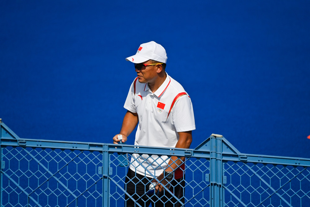 新华社记者 张笑宇 摄7月20日,中国女子曲棍球队教练刘双全(后)与队员