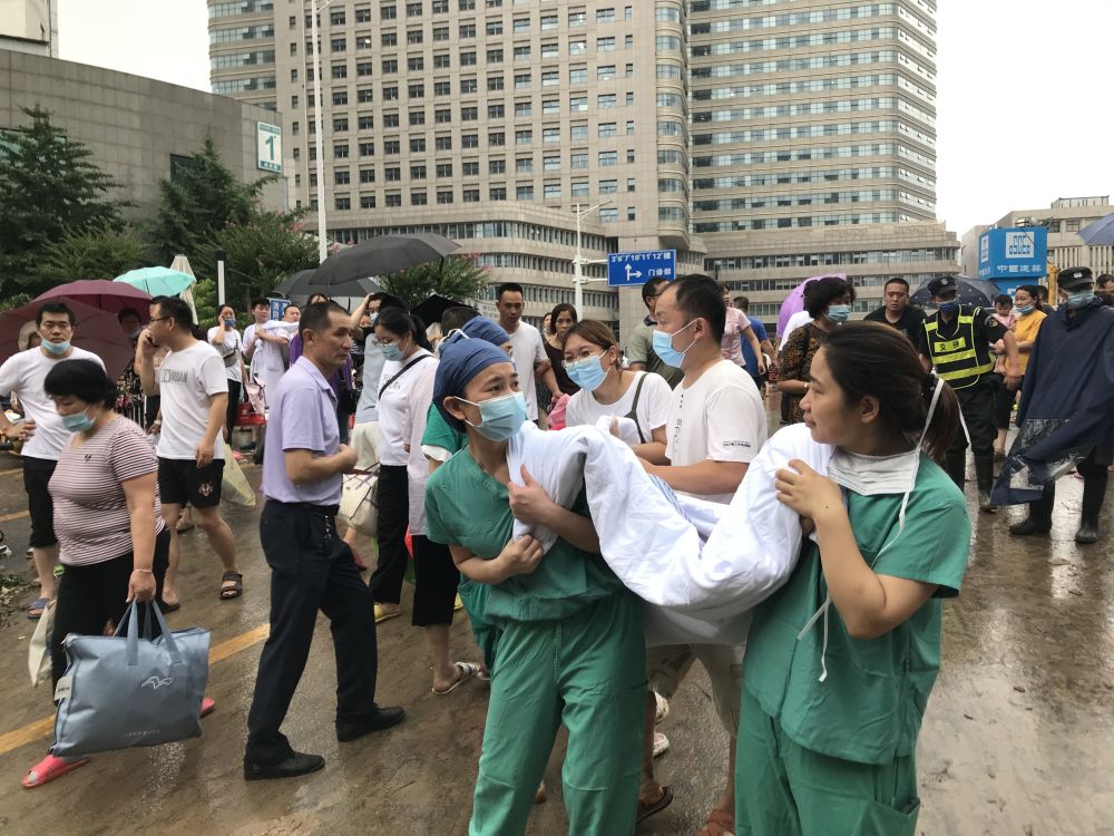 直击郑大一附院河医院区病人转运现场医护人员用被子当担架抬人